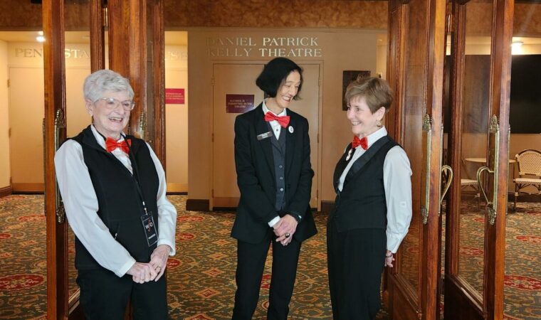 Three smiling volunteers standing in the Capitol theatre lobby. They are getting ready to welcome patrons to the show!